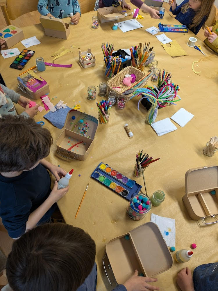 Die Kinder verzieren ihre Koffer auf unterschiedliche Art