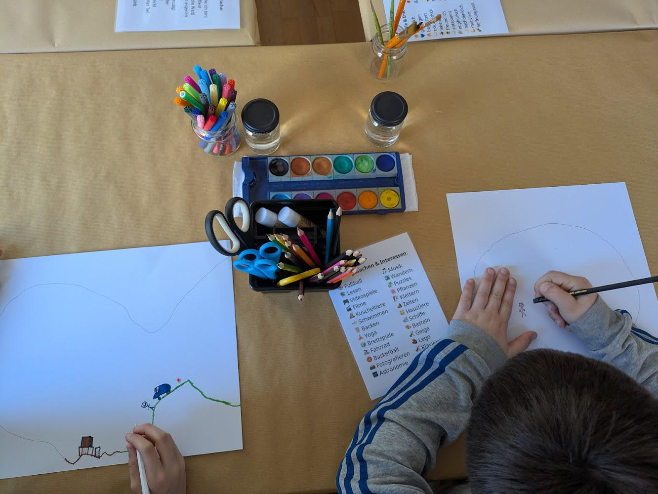 Kinder zeichnen die Konturen ihres Kopfes auf einem Papier nach